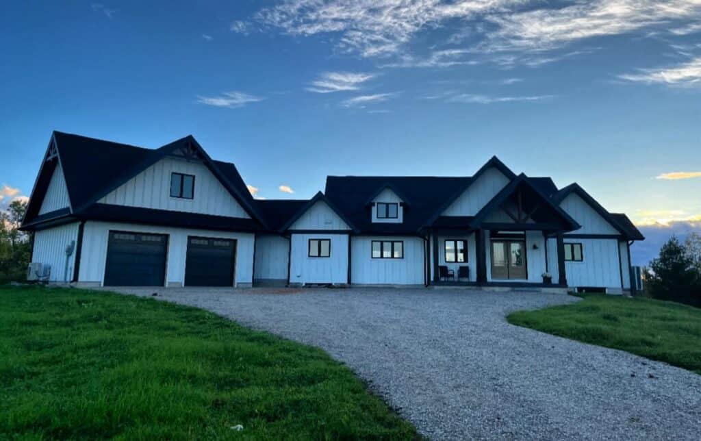 Modern farmhouse at sunset with spacious driveway